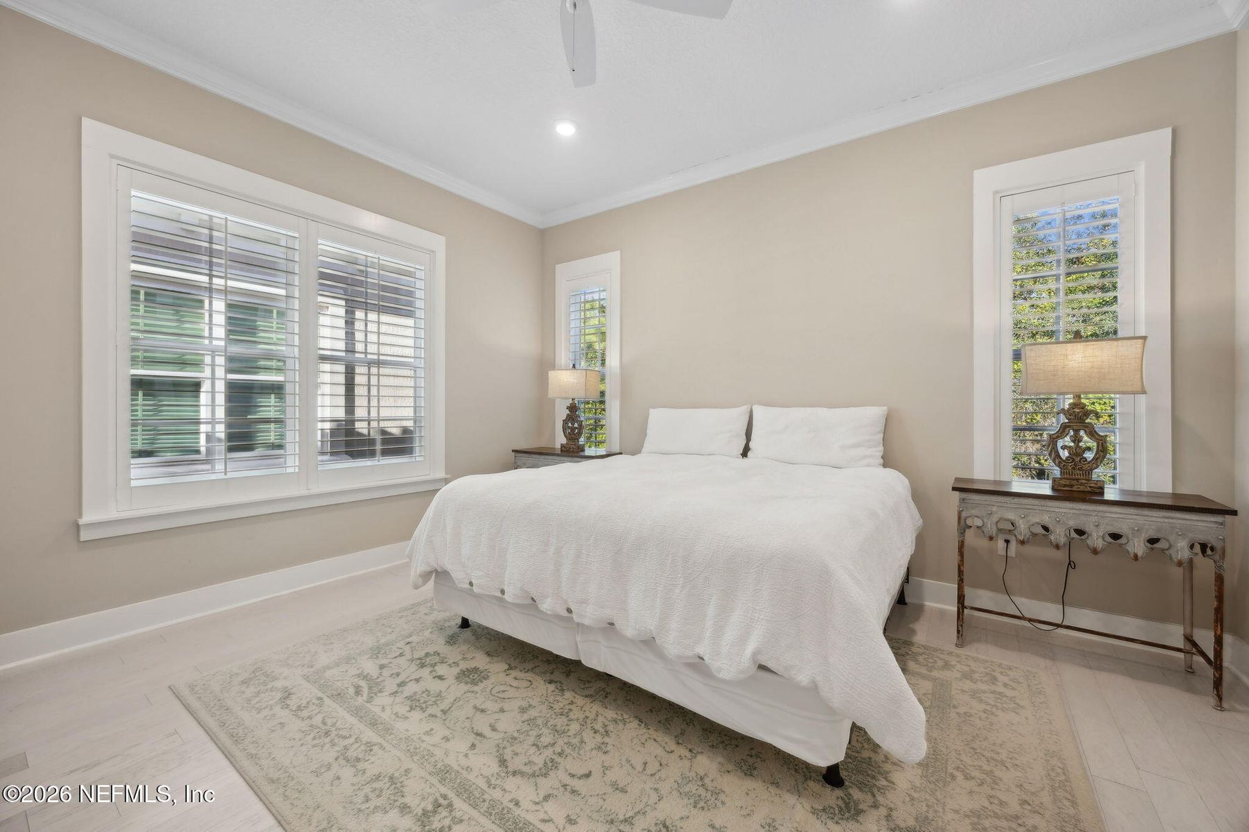 Lower-level bedroom with ceiling fan and shutters
